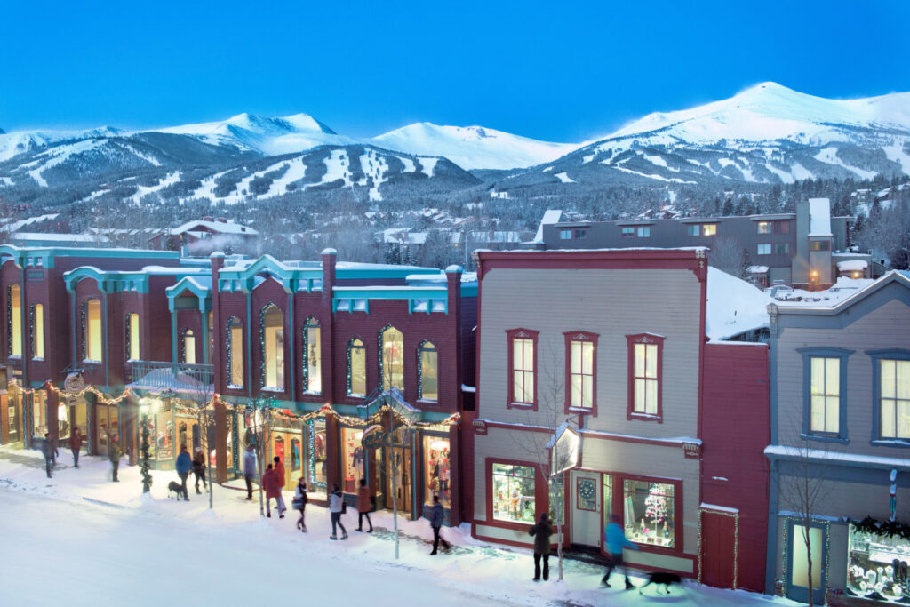 Image of the town of breckenridge in the foreground with the 5 peaks of breck in the background at dusk